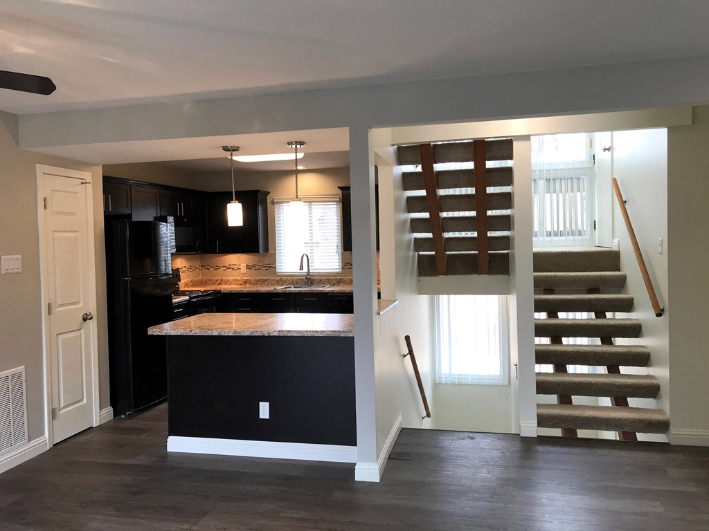 a kitchen with an island and stairs in a house