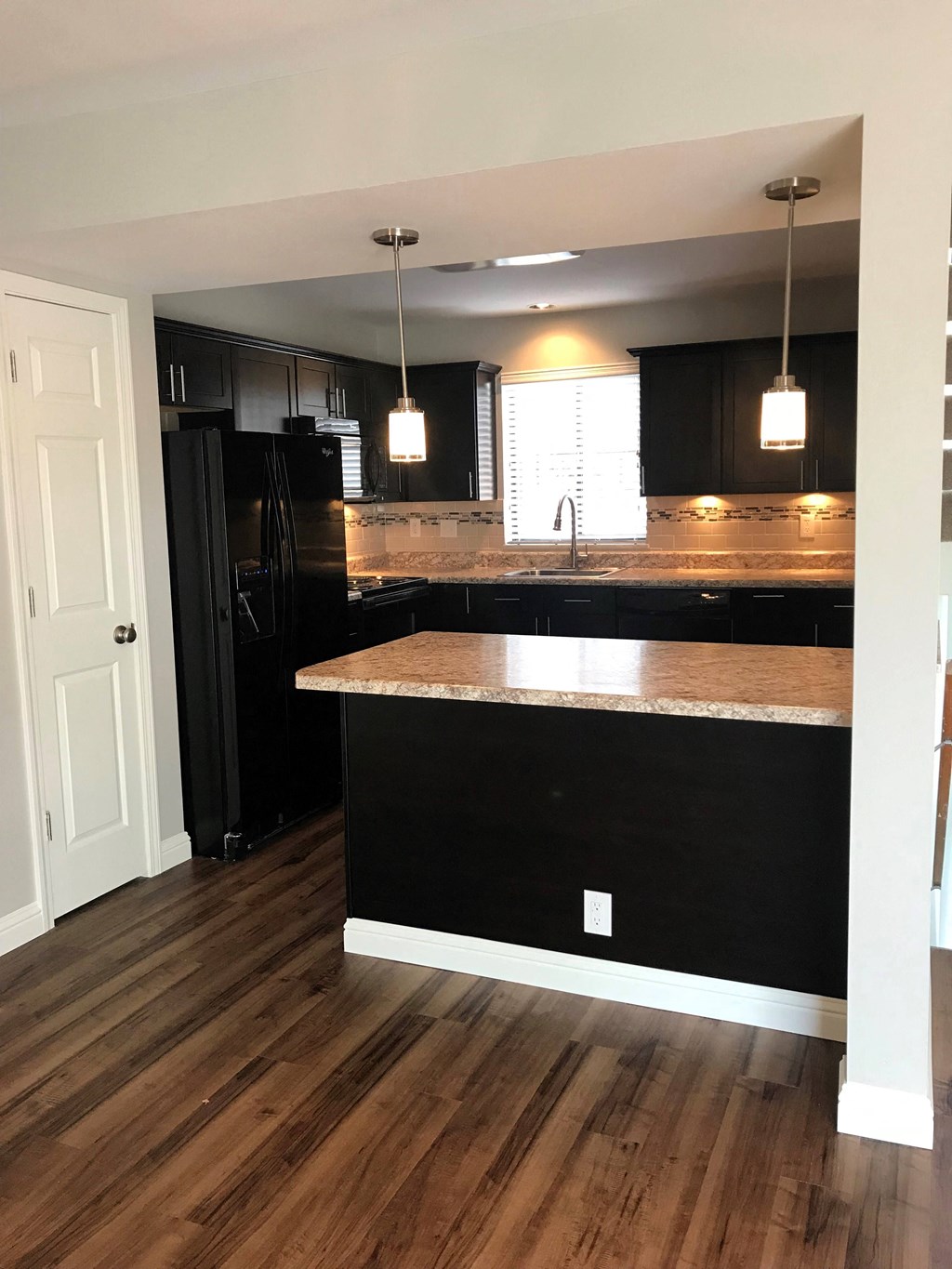 a kitchen with black cabinets and a counter top