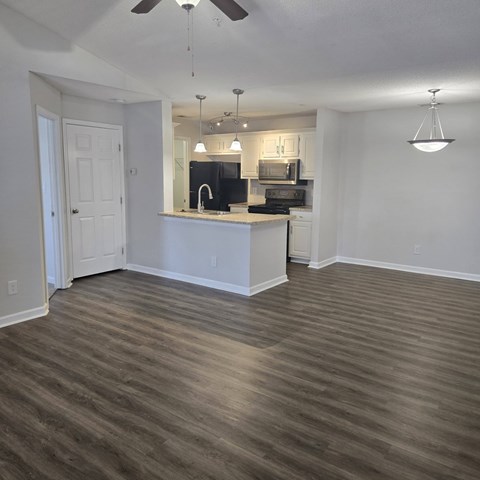 A kitchen with a white counter and a black stove top oven.