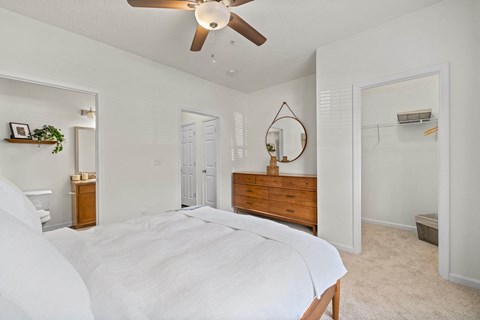 A bedroom with a large bed and a ceiling fan.