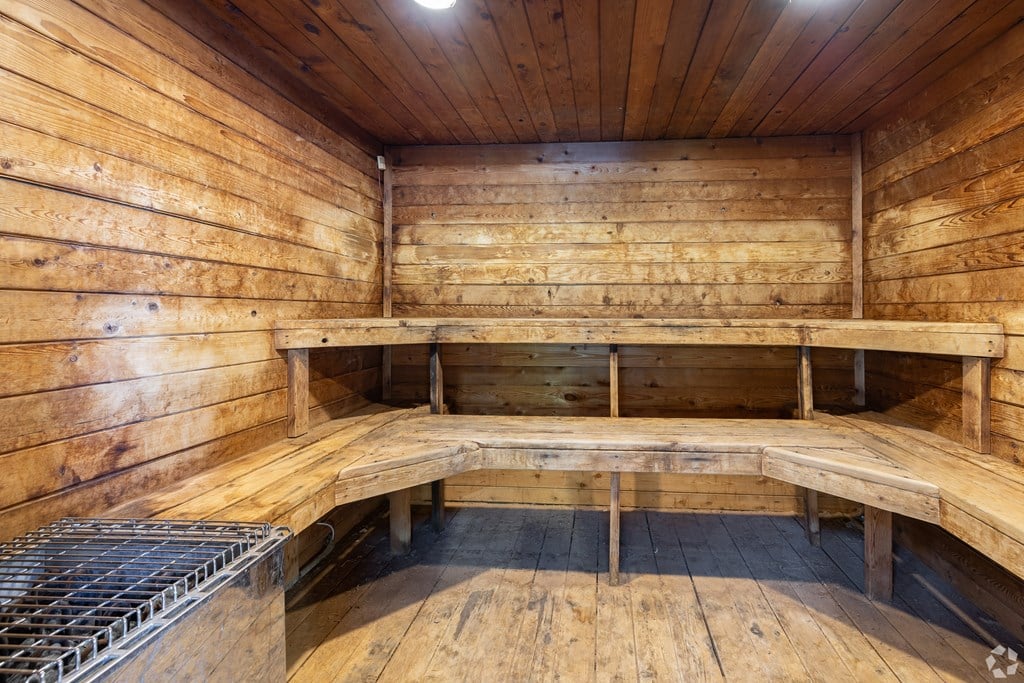 A wooden sauna with benches and a heater.