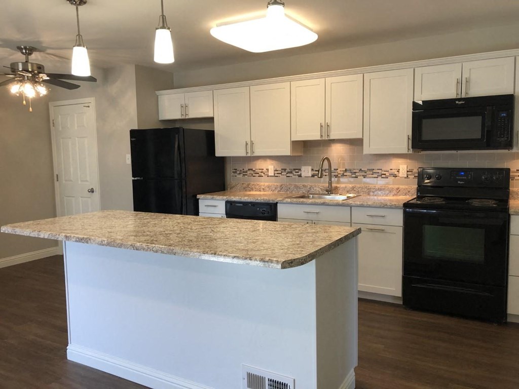 a kitchen with black appliances and a granite counter top