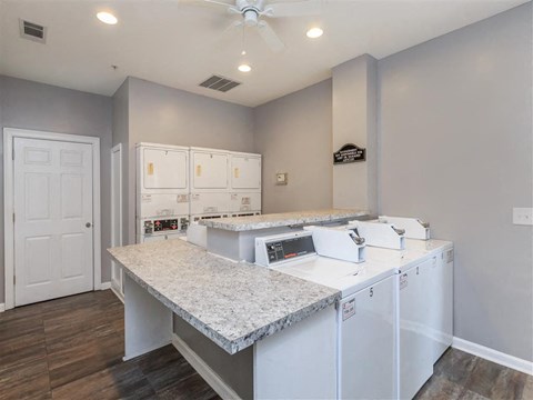 A kitchen with white cabinets and a marble countertop.