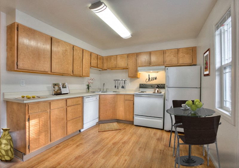 A kitchen with wooden cabinets and a white refrigerator.