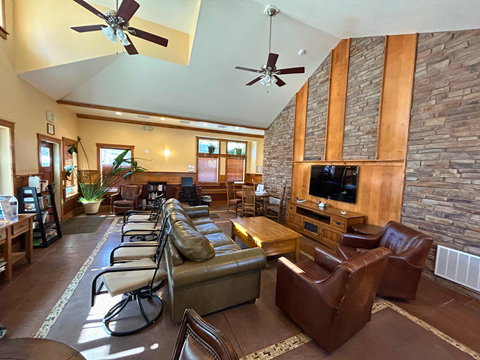 A living room with a stone wall and a flat screen TV.