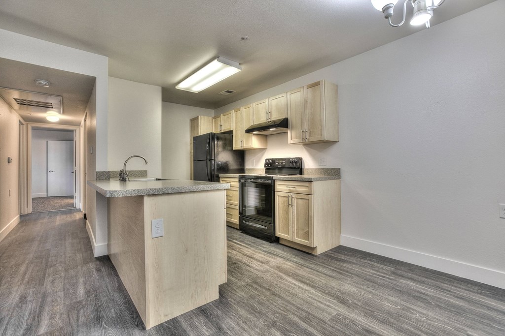 A kitchen with a sink, stove, and oven.