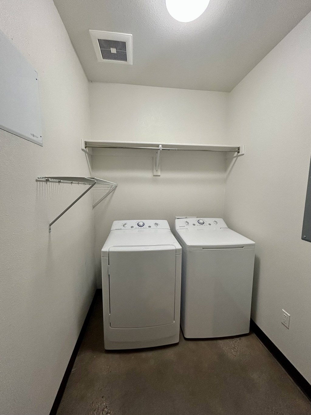 Two washing machines in a small laundry room.