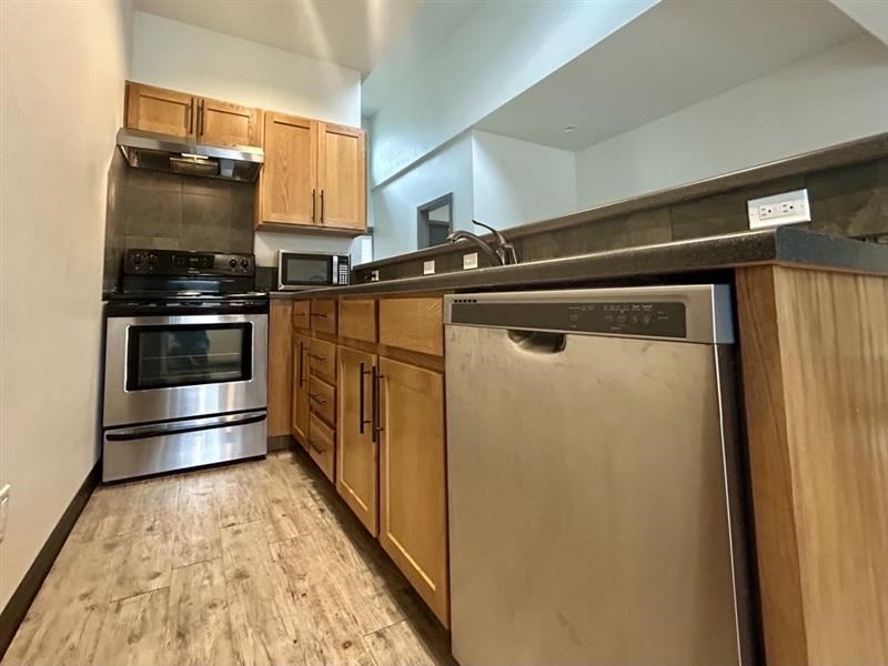 A modern kitchen with wooden cabinets and stainless steel appliances.