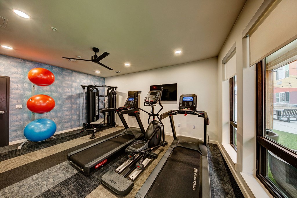 Fitness room with treadmills, weights, and exercise balls