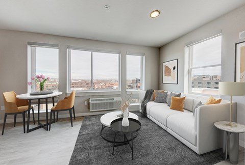 a living room with a white couch and a table    and a window