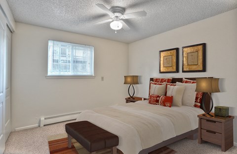 a bedroom with a large bed and a ceiling fan