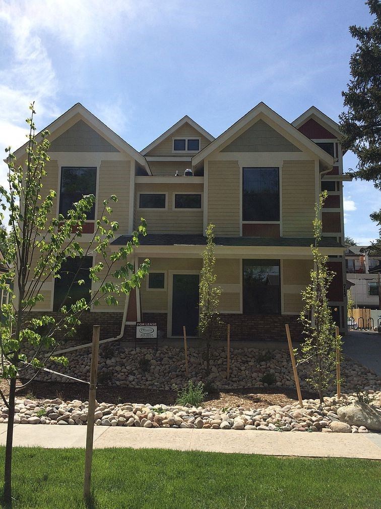 a house with a lawn and trees in front of it