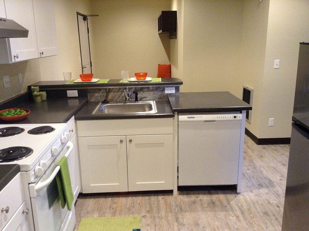 an empty kitchen with a stove sink and dishwasher