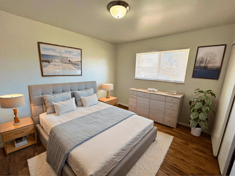 A bedroom with a large bed and a nightstand with a lamp.