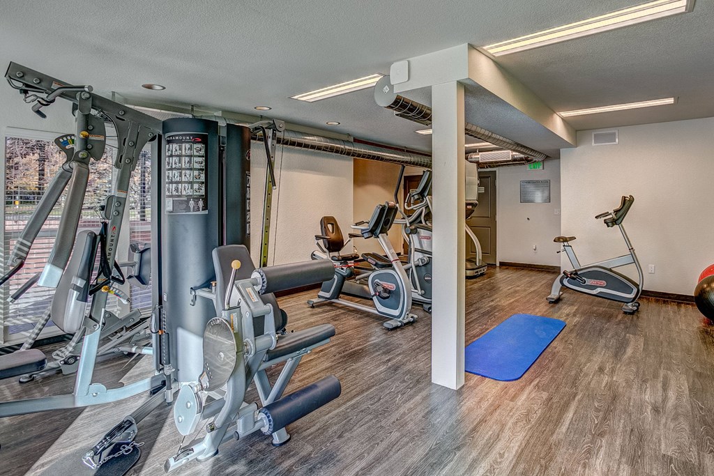 A woman is working out on a rowing machine in a gym.