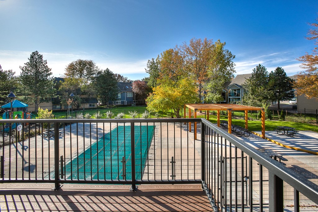 A playground with a green slide and a metal railing.
