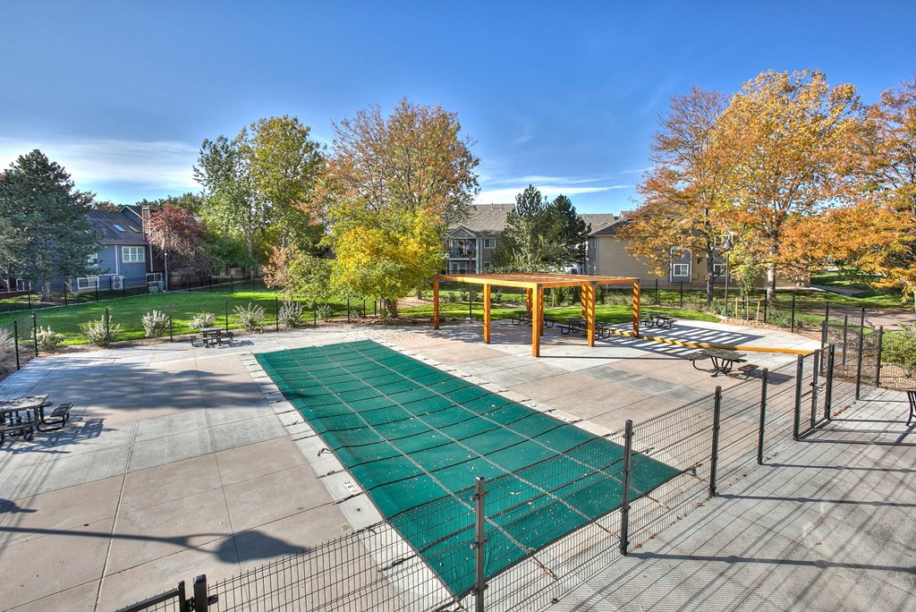 A playground with a green surface and a yellow structure.