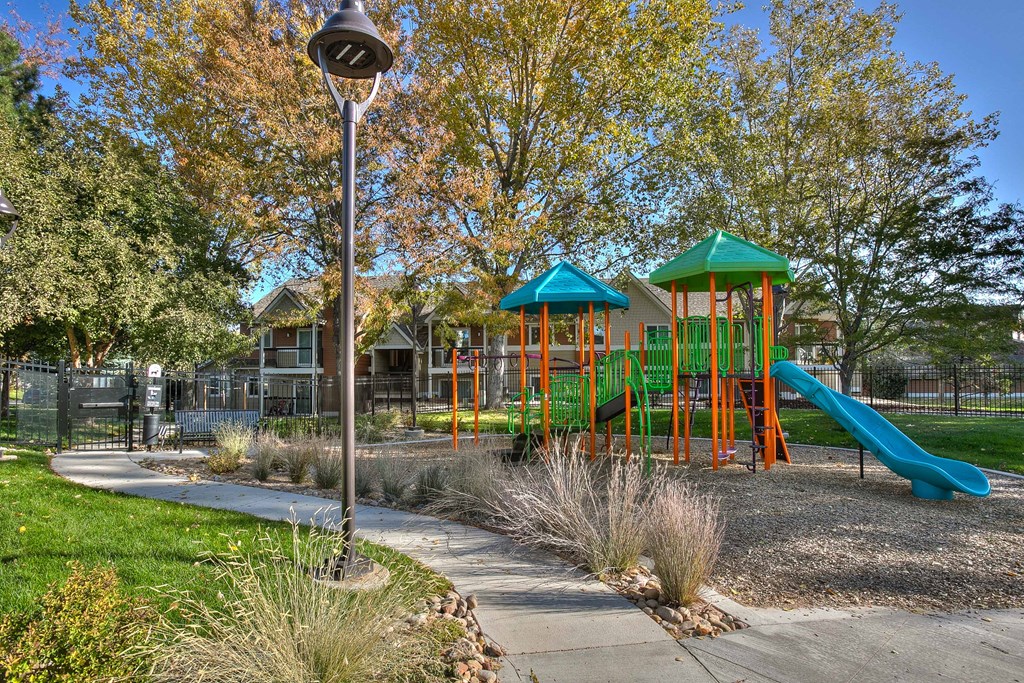 A playground with a green slide and a blue roof.