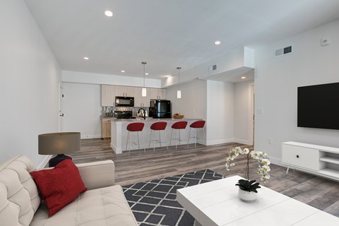 A modern living room with a white sofa and a black television.