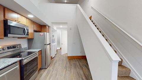 a kitchen with stainless steel appliances and a staircase      and stairs