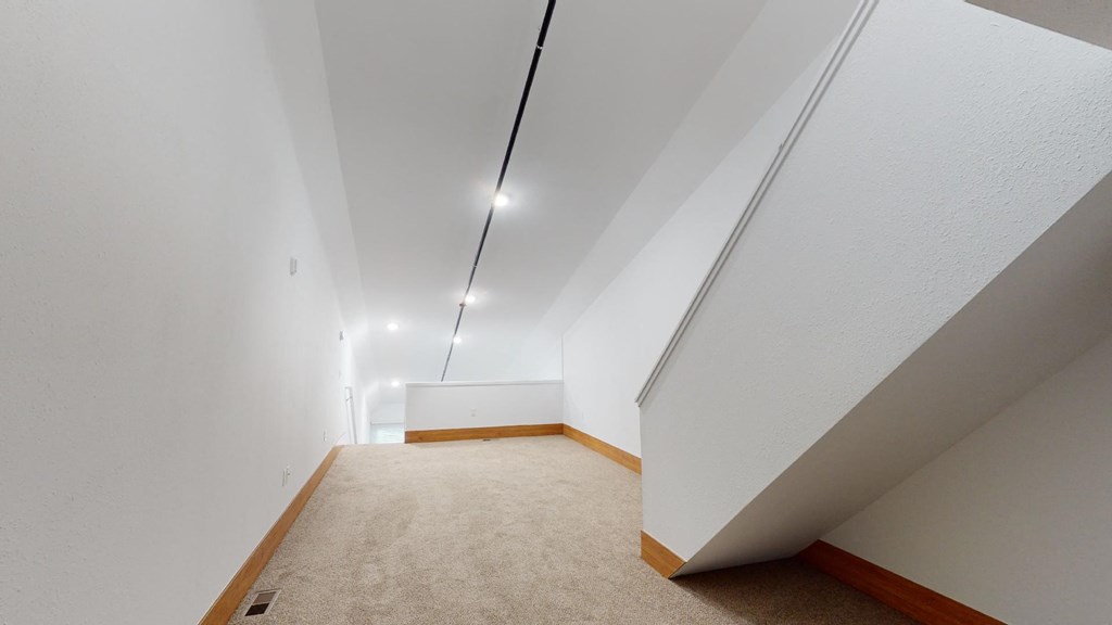 a room with a carpet and white walls and ceilings