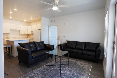 a living room with leather couches and a glass coffee table