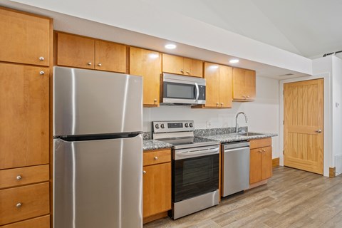 A kitchen with wooden cabinets and stainless steel appliances.
