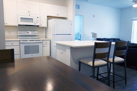 a kitchen and dining room with white appliances and white cabinets