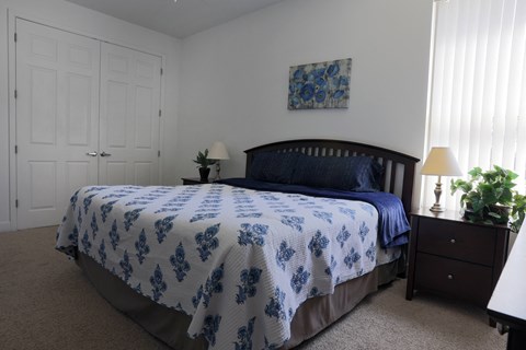 a bedroom with a bed and a white and blue comforter