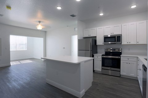 an empty kitchen with white cabinets and stainless steel appliances