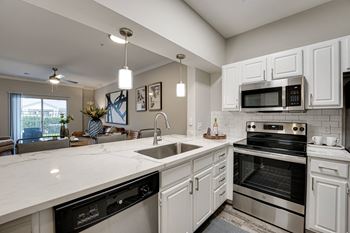 a kitchen with white cabinets and stainless steel appliances  at Highland Luxury Living, Texas, 75067