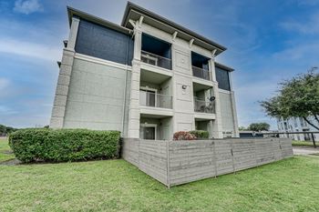 an apartment building with a wooden fence in front of it  at Highland Luxury Living, Texas, 75067