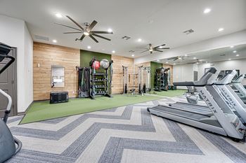 a gym with treadmills and other exercise equipment at the enclave at woodbridge apartments in  at Limestone Ranch, Lewisville, TX