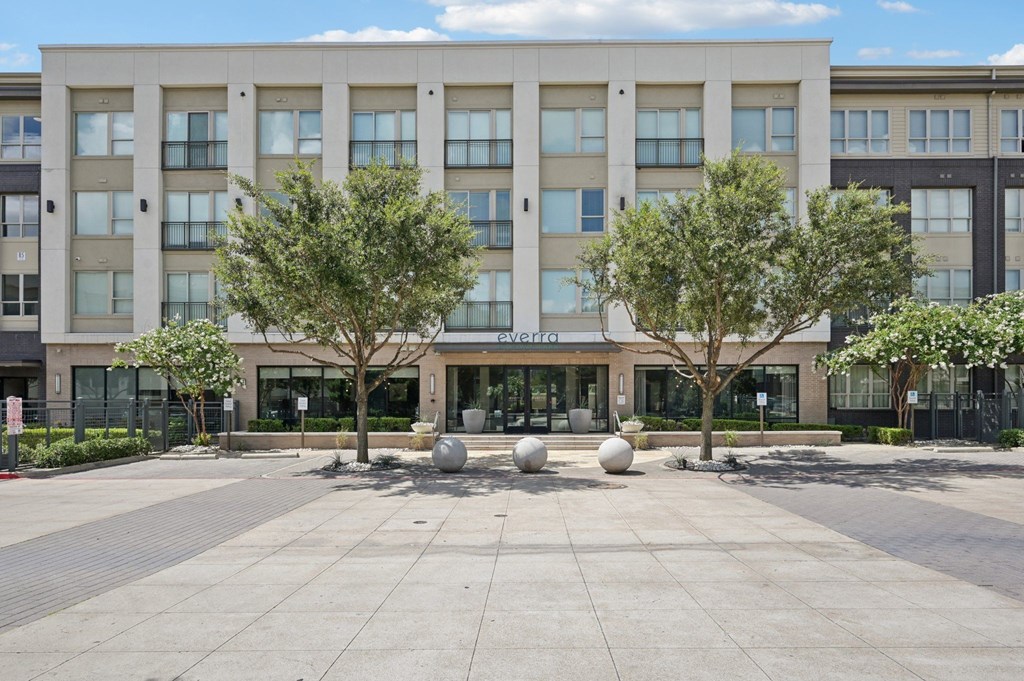 A large building with a lot of windows and trees in front at Everra Midtown Park Apartments, Dallas 75231