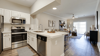 an open kitchen and living room with a large counter top  at Highland Luxury Living, Lewisville