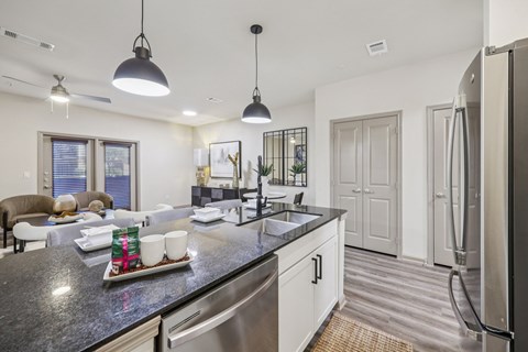 A modern kitchen with a black granite countertop and stainless steel appliances.