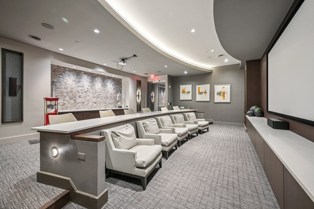 A modern home theater with a curved screen and comfortable seating at Everra Midtown Park Apartments, Texas, 75231