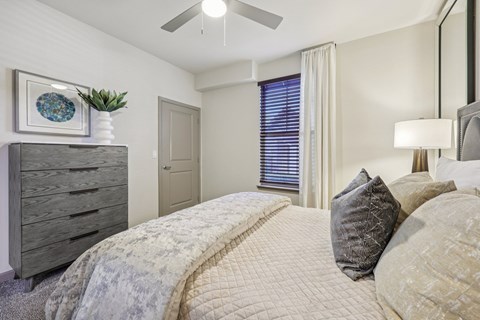 A bedroom with a large bed and a dresser.