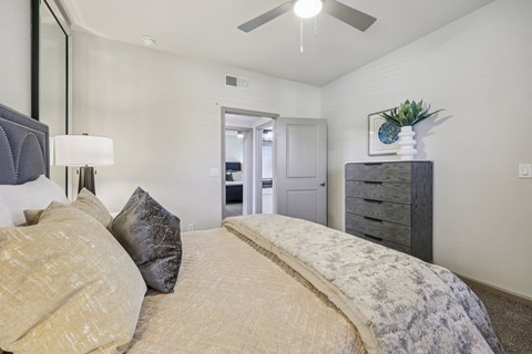 A bedroom with a large bed and a ceiling fan.