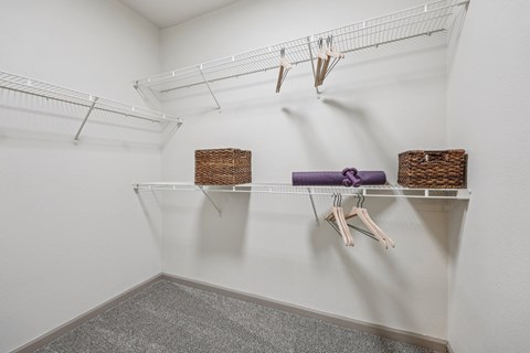 A white closet with a purple hanger and two baskets.