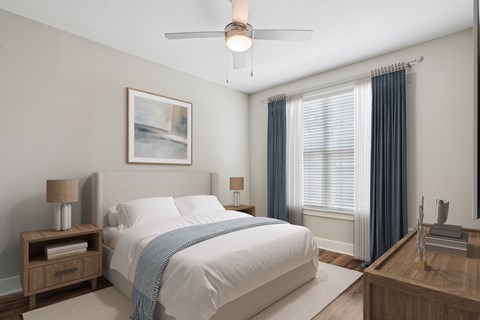 A bedroom with a large bed and a ceiling fan.