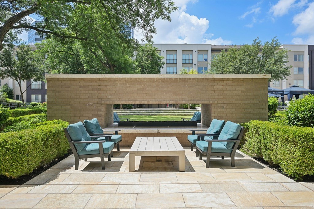 A patio with a bench, chairs and a table at Everra Midtown Park Apartments, Dallas 75231