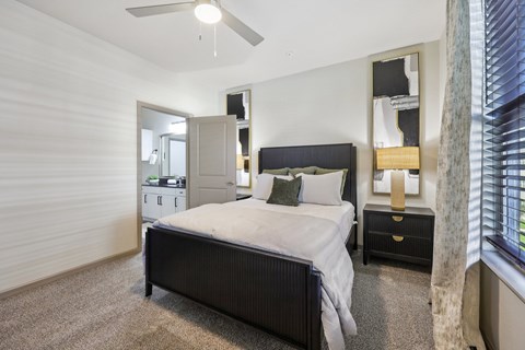A bedroom with a bed, nightstand, and a ceiling fan.