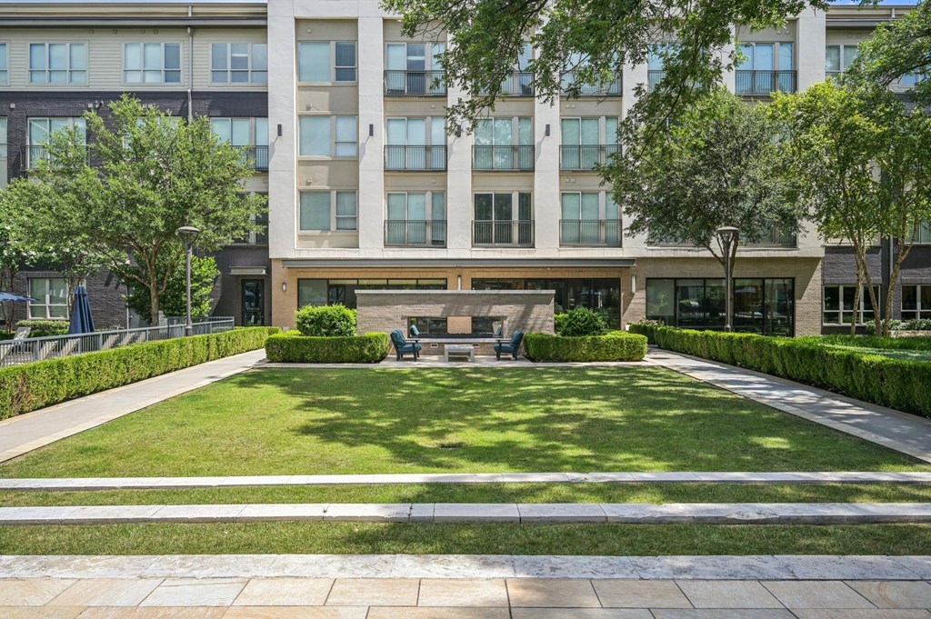 A large building with a green lawn in front at Everra Midtown Park Apartments, Dallas, Texas