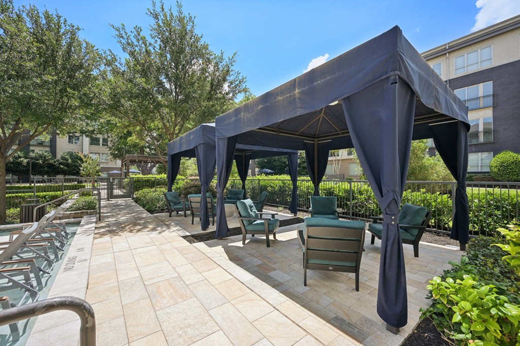 A patio with a canopy and chairs at Everra Midtown Park Apartments, Dallas