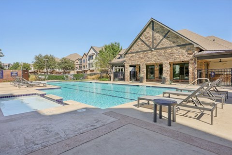 A swimming pool with a stone building in the background.
