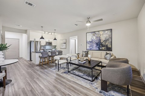 A modern living room with a grey sofa, a black coffee table, and a large abstract painting on the wall.
