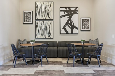 A black and white abstract painting hangs above a black couch.