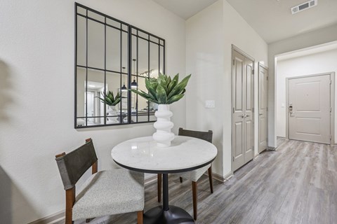 A dining room with a white table and chairs.