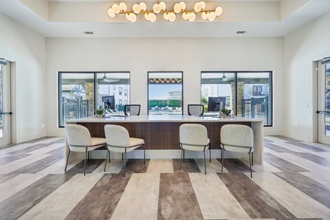 A modern office space with a long desk and chairs.